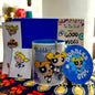Collection of 'Bubbles' themed merchandise including a mug, keychain, and coasters on a colorful surface.